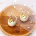 Detail shot of vintage white enamel hoop earrings with gold interior on a wooden plate. - Clasp Back / White (E3036 Gold White)