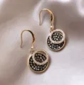 Detailed view of elegant gold circular earrings with dark crystals on silk fabric - Vintage Round Plate Style (E0267)
