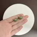 Hand holding vintage green enamel hoop earrings featuring elegant gold-plated finish - Clasp Back / Green (E3036 Gold Green)