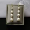 Elegant long drop earrings with four graduated white pearls on a grey jewelry display pad - Four-Bead Tassel Hook Style (E0196)