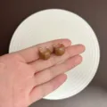 Chic caramel brown enamel hoop earrings variant shown in hand against white dish - Clasp Back / Light Coffee (3E3036 Coffee)