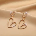 Elegant gold-toned heart-shaped drop earrings with sparkling rhinestones. - Double Heart Rhinestone Style (E0249) / Gold