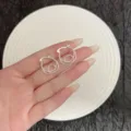 Minimalist silver spiral hoop earrings with geometric design shown on hand - Geometric Spiral Double Ring Style (E4905) / Silver