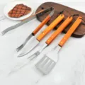 4-piece BBQ tool set with wooden handles featuring spatula, fork, knife and tongs - Multipurpose 4-Piece Grill Tool Kit