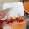 Close-up detail showing elegant gold hoop earrings with red roses and shiny crystals - Red Lacquered Rose Ear Buckle (E3053 Red Gold)