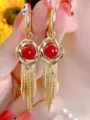 Elegant gold tassel earrings featuring a vibrant red bead center in a twisted metal knot - Knotted Red Bead Tassel Style (E3568 Gold Red)
