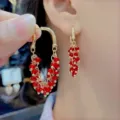 Elegant gold-tone hoop earrings featuring cascading red faceted bead drops for women - Clustered Bead Tassel Hoop Style (E3438)