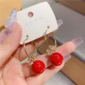 Elegant golden hoop earrings featuring a sparkling flower motif and a vibrant red bead - Rhinestone Flower Red Bead Style (E3333)