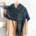 Vue détaillée d'une écharpe vintage à carreaux gris foncé avec franges sur un manteau. - Z256 / Noir