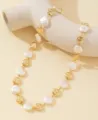 Dettaglio di una collana con perle barocche e dischi dorati martellati su fondo crema. - Stile Disco Metallico Martellato (XL3701) / Bianco (02 Oro)
