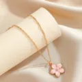 Dettaglio macro di un elegante ciondolo fiore di ciliegio in smalto rosa e oro - Rosa