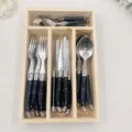 Detail view of 24-piece black cutlery set organized in a natural wooden storage box - 24 Pieces With Wooden Box
