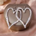 Large silver hammered lava heart-shaped drop earrings for women on a jewelry box - Lava Heart Earrings / Silver