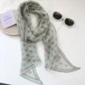 Primer plano de bufanda verde de lunares con gafas de sol blancas y tarjeta decorativa. - Verde con lunares
