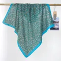 Close-up of a blue floral cotton square scarf with retro aesthetic hanging on a rod - RY-27