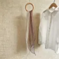 Detailansicht eines weichen braun-weiß gestreiften Chiffon-Schals an einem Holzring - 150cm / Braune Streifen