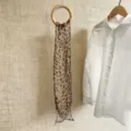 Detaillierte Ansicht eines eleganten Chiffonschals mit Leopardenmuster an einem Holzring - 150cm / Hellbraun Leopard