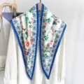 Detailed view of floral print triangular silk scarf with blue border draped over a white shirt - Triangle Scarf (TBSJJ116) / 87*130CM / Blue