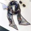 Detalle de una bufanda de gasa con elegantes patrones circulares abstractos en azul y marrón oscuro - Racimos de flores Monet