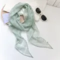 Elegante bufanda estrecha de gasa verde menta con patrón blanco sobre accesorios de estilo. - Sueño floral verde menta