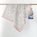 Detail view of 100% cotton floral square scarf with pink border hanging on rod. - 65*65cm / Pink