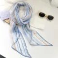 Detalle de una bufanda de gasa con rayas retro azules y naranjas, textura ligera - Rayas Azules Naranjas
