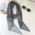 Vista detallada de una bufanda larga de gasa plisada gris con textura de rayas verticales - Rayas Grises