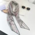 Detalle de bufanda larga de gasa con rayas retro rojas y grises y gafas de sol - Rayas Rosa Gris