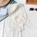 Primer plano de un pañuelo de seda de gasa ligera con estampado de lunares dorados. - Lunares Blancos