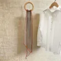 Bufanda larga de gasa con lunares colgada en un aro de madera junto a camisa - 150cm / Moneda Marrón