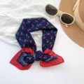 Close-up of navy blue scarf with cherry pattern and red polka dot border detail. - MBFJ07 / 65x65cm / Navy Blue