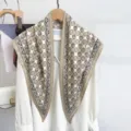 Detailed view of large triangular scarf with geometric grid pattern and paisley border. - 87x130cm / Khaki