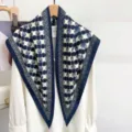 Detailed view of navy blue and white checkered silk triangle shawl on a hanger. - 87x130cm / Blue