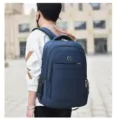 Man wearing a large navy blue backpack, showing side profile and comfortable shoulder straps. - 09 / Blue