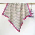 Vue détaillée d'un carré de coton élégant à motifs de vagues vertes suspendu à une barre d'or. - Vert Clair Ondulé