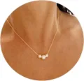 Close-up shot of a minimalist gold chain necklace with three elegant white pearls - Triple Pearl Pendant Style (04 Gold) / Gold