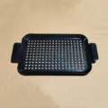 Close-up detail of a rectangular black enamel perforated BBQ grill roasting tray - Small Size 33x18.5x2cm