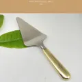 Elegant stainless steel cake server featuring a polished gold handle for baking - Solid Turner / Gold