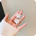 Close-up of elegant white flower stud earrings held in hand for size reference. - Multi-layer Petal Flower Style (E1715)