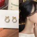 Elegant gold wreath bow earrings with pearls and crystals, featuring a model wear view - 蝴蝶结花环款式(E1226)