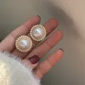 Detail shot of vintage-style round pearl stud earrings with golden textured border - Pearl Woven Ring Style (E1075)
