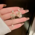 Elegant asymmetric bowknot pearl drop earrings with sparkling rhinestones in gold. - Gold Asymmetric Bowknot Pearl Tassel Style (E1708)