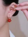 Detailed view of elegant red faceted crystal ball earrings worn on a model's earlobe - Faceted Ball Style (E2555) / Red