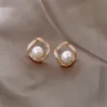 Elegant gold pearl stud earrings with crystal square frame on taupe satin background cloth. - Square Twisted Pearl Style (E1473)