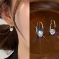 Elegant gold hoop earrings with sparkling round zircon on model and wooden tray. - Rhombus Open Ear Clip Style (E1847)