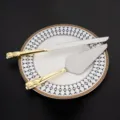 Nahaufnahme der goldenen herzförmigen Griffe an einem Hochzeitstorten-Set - Wide head gold silver suit