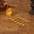Elegant golden swan base with 6 matching coffee dessert spoons on a vintage wood table. - Swan Base with 6 Spoons / Gold