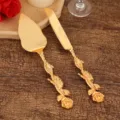Elegantes goldenes Tortenheber- und Messerset mit verzierten Griffen in Rosenform - Rose Stil / Gold