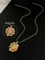 Λεπτομερής προβολή της μπροστινής και πίσω όψης ενός χρυσού vintage μενταγιόν - Κολιέ Μενταγιόν Λουλούδι με Πολύτιμους Λίθους