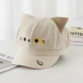 Detail view of beige newsboy cap with cute 3D cat ears and embroidered cat face - Adult 55-58cm / Beige